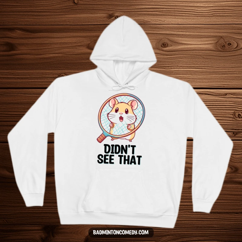 Funny hamster peeking from behind a huge racket, looking surprised on a cozy badminton hoodie, a funny gift.